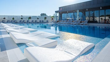 Una piscina techada, una piscina al aire libre de temporada, sombrillas