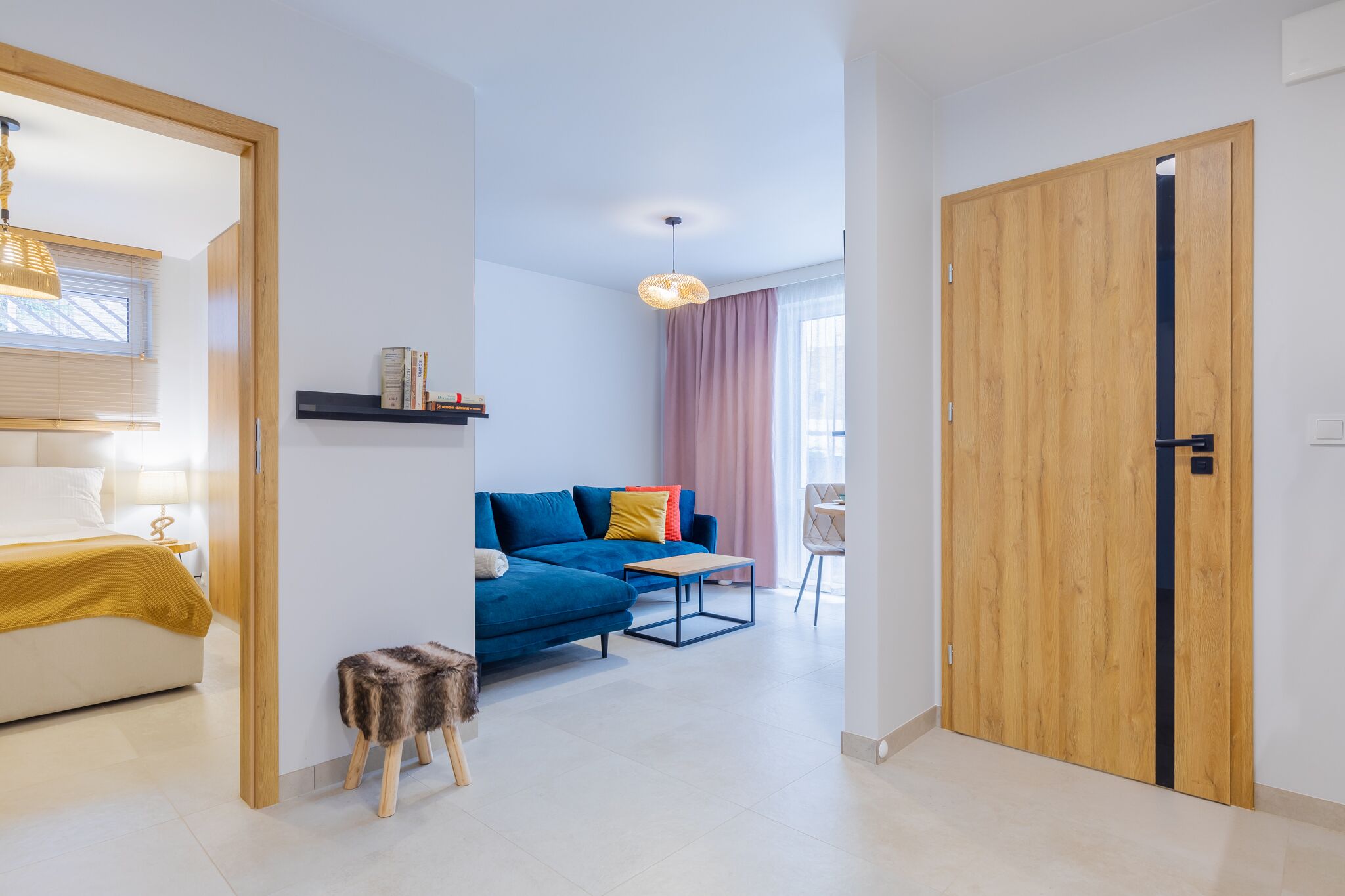 Un salon moderne avec un canapé, une petite table et une porte en bois.