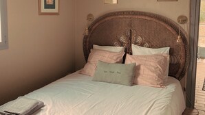 A neatly made bed with a headboard, a chandelier, and two framed pictures on the wall. - Domaine Au Bon, La Sud - 5min D'hossegor (Angresse)