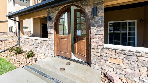 A multi-story building with a stone facade, a large wooden double door, and a number "5621" above the entrance.