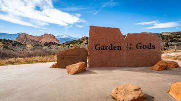 Ein großes Schild mit der Aufschrift 'Garden of the Gods' vor einer gebirgigen Kulisse.