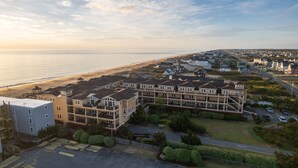 A coastal residential area with multi-story houses, a beach, and a clear sky. - Coast Time 2 Bedroom Condo at Croatan Surf Club (Kill Devil Hills)