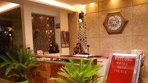 Un mostrador de recepción con un cartel que dice "HOTEL MOTI PALACE, BIENVENIDOS".