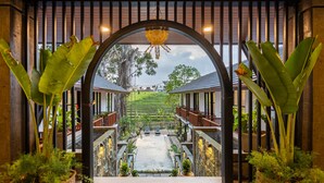 A covered walkway with a view of a water feature and a terraced landscape. - Paripadi Studio Canggu (Canggu)