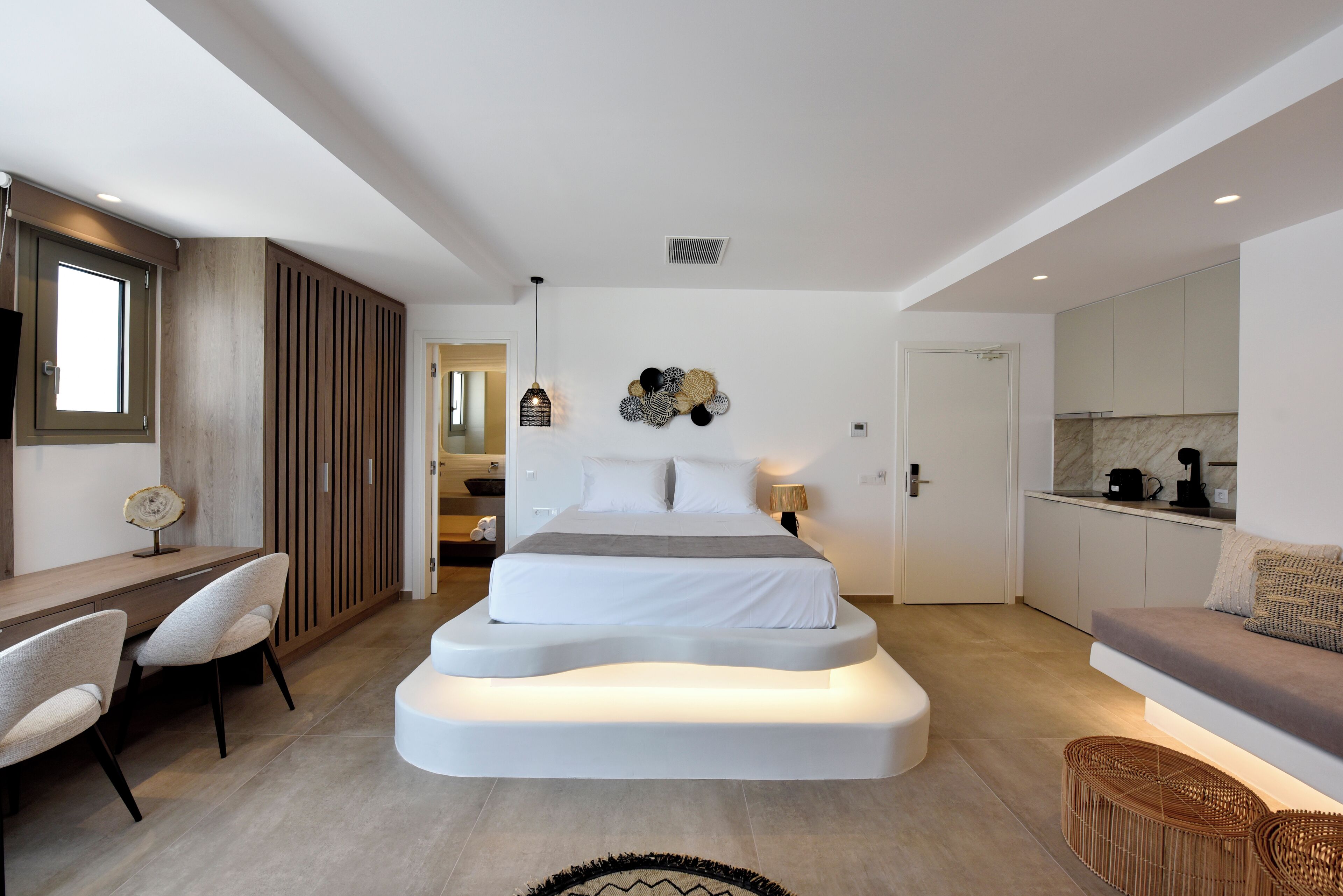 Un dormitorio moderno con un diseño de cama original, un escritorio y un sofá.