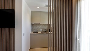 Une cuisine moderne avec un téléviseur à écran plat fixé au mur, un pare-feu en marbre et une cloison en bois.