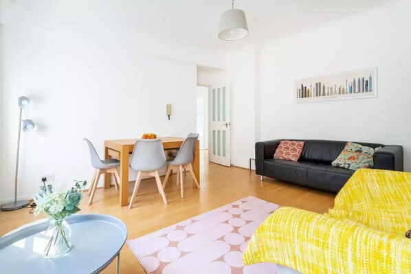 Un salon comprenant un canapé, une table à manger avec des chaises, une table basse et une lampe.
