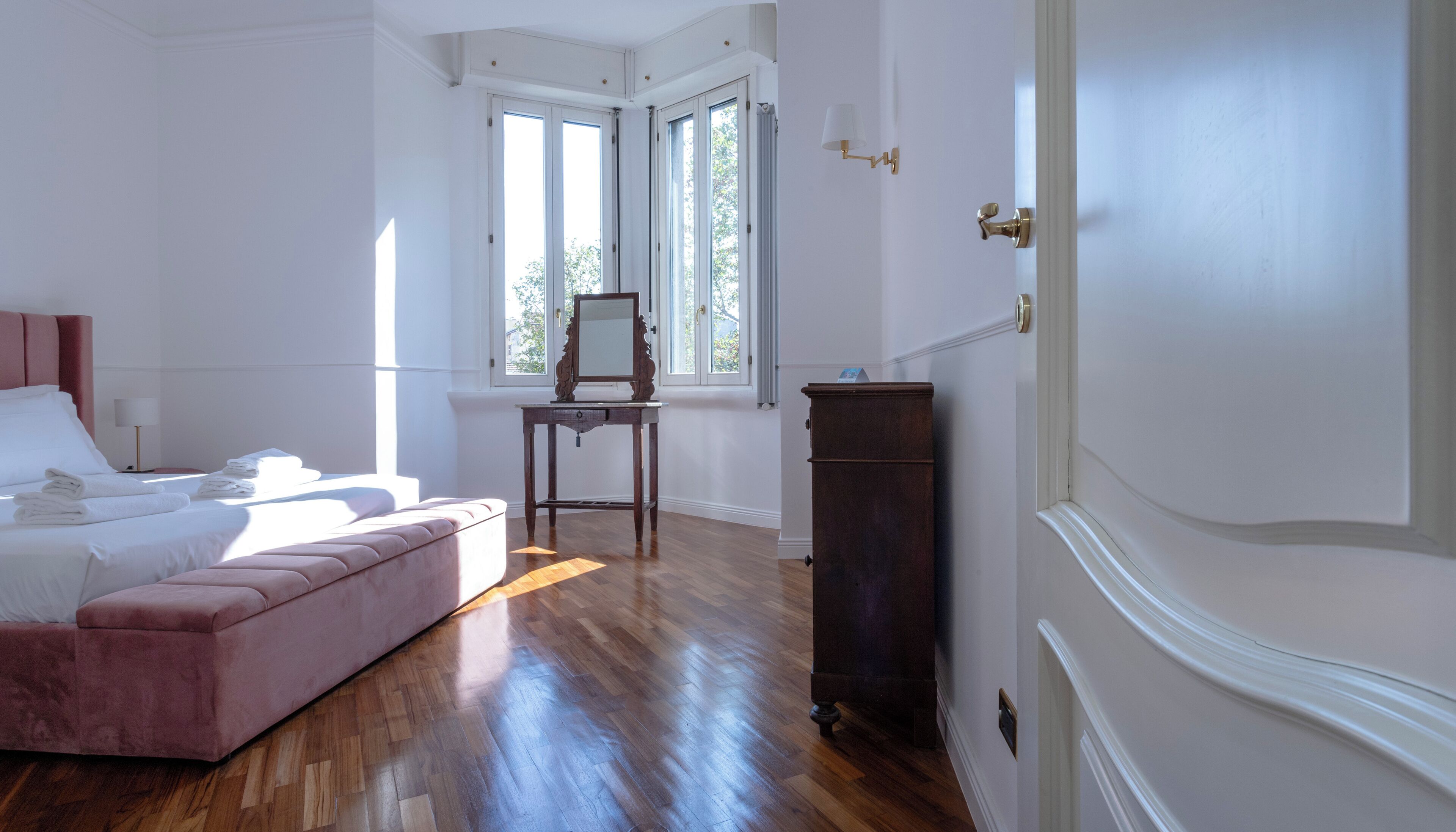 Un dormitorio con cama, cómoda, mesita de noche y ventana con cortinas.