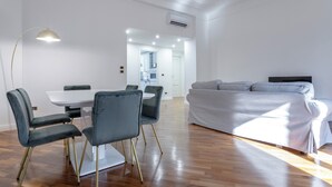 A modern living room with a dining area, a sofa, and a kitchen in the background. - Italianway - Bodio 6 (Milan)