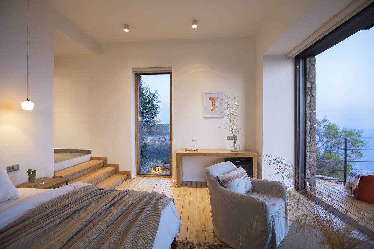 Une chambre moderne dotée d’un grand lit, d’un coin salon et offrant une vue sur l’extérieur.