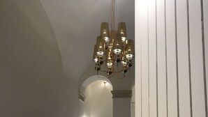 A staircase with a modern design, featuring a light-colored wall and a patterned rug at the bottom. - Motta Palace Apartments and Rooms (Motta Sant'Anastasia)