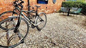A bicycle parked in front of a brick building with a gravel ground. - Centralellesmere - Sleeps4 - Parking - Petfriendly (Ellesmere)