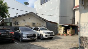 A parking area with three cars parked in front of a building with a satellite dish and air conditioning units. - Hotel O Edotel Smkn 5 Palopo Near Bukit punai (Palopo)