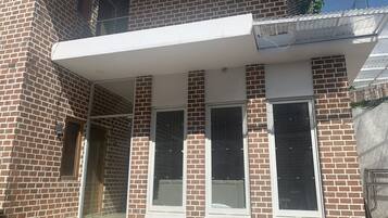 A two-story brick building with large windows and a covered balcony.