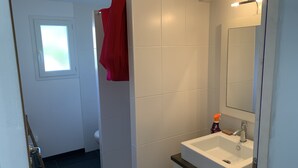 A bathroom with a white sink, mirror, and tiled walls.