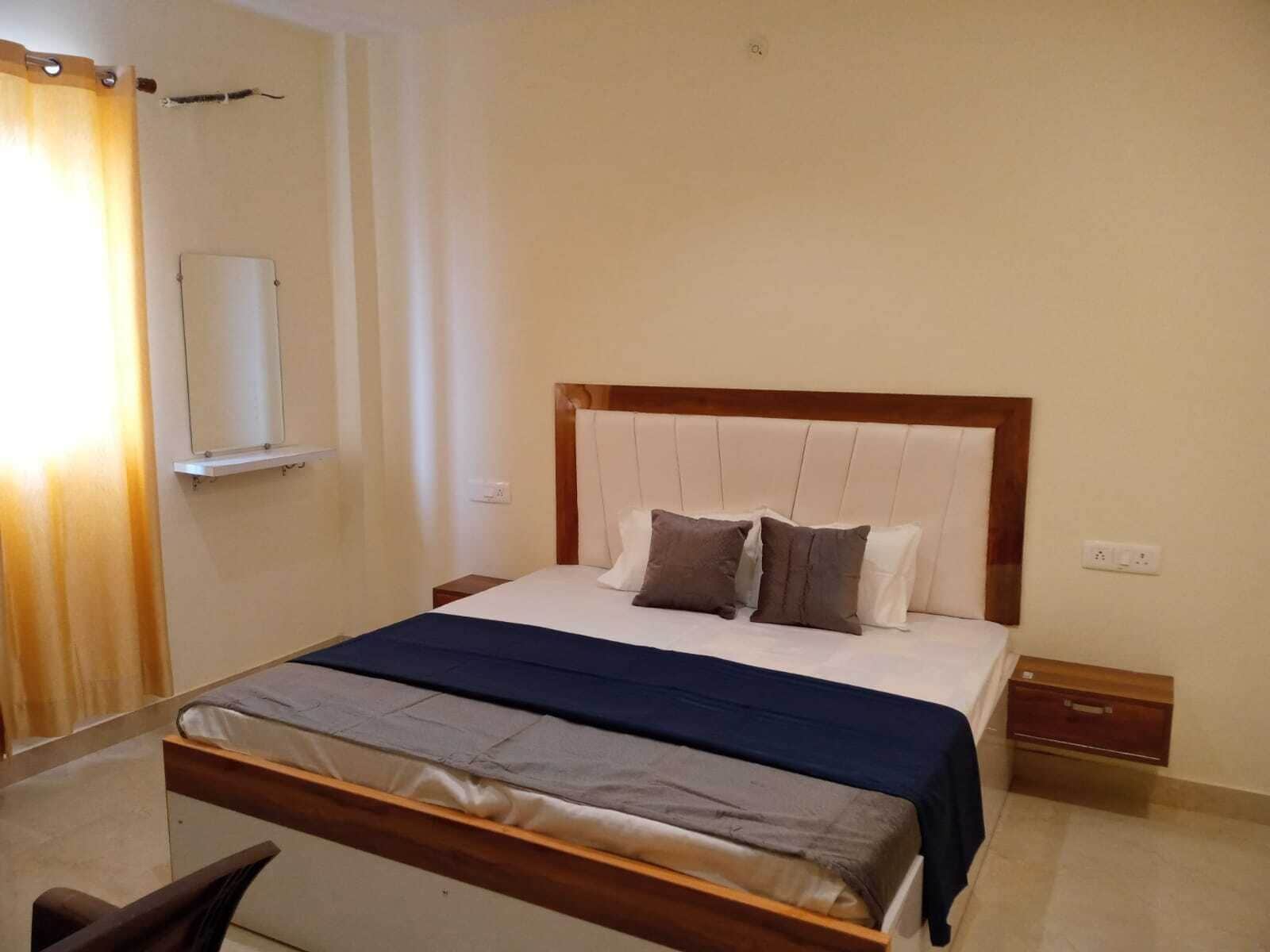 Une chambre à coucher bien rangée, avec un lit en bois, une table de chevet et une petite table de nuit.