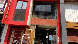 Un edificio con fachada roja y un letrero que dice 'Jaiswal Confectionery & Daily Needs'.
