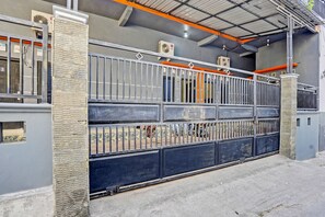Ein begrenzter Zugang mit einem Metallzaun, Klimaanlagen und einem Betonboden.