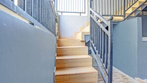 Un escalier avec des marches en bois et des rampes en métal menant à un niveau supérieur.