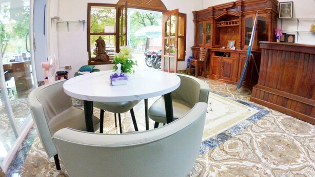 A room with a round table and four chairs, a wooden cabinet, and a patterned carpet. - Sarah Guest House (Siem Reap)