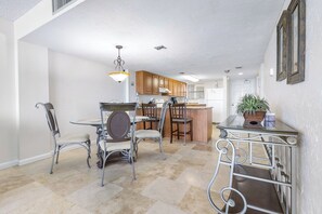 A spacious kitchen with a dining area, featuring a central island, wooden cabinets, and a hanging light fixture. - Oceanfront Condo on traffic free beach - Great views from 403 Lighthouse Shores (Ponce Inlet)