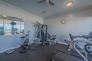 A gym with cardio equipment, weight machines, and a mirror. - Oceanfront Condo on traffic free beach - Great views from 403 Lighthouse Shores (Ponce Inlet)