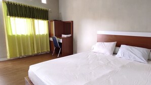 A hotel room with a large bed, a wooden wardrobe, and a window with green curtains. - OYO 93051 Wisma Syariah Buloe Near Lapangan Abubakar Lambogo Batili Enrekang (Enrekang)