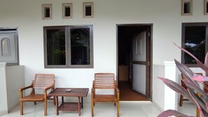 A balcony with wooden furniture, a refrigerator, and a door leading to a kitchen. - OYO 93051 Wisma Syariah Buloe Near Lapangan Abubakar Lambogo Batili Enrekang (Enrekang)