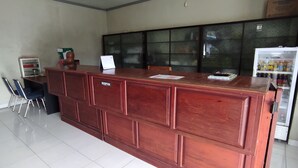 A reception desk with a sign, a refrigerator, and a cabinet. - OYO 93051 Wisma Syariah Buloe Near Lapangan Abubakar Lambogo Batili Enrekang (Enrekang)
