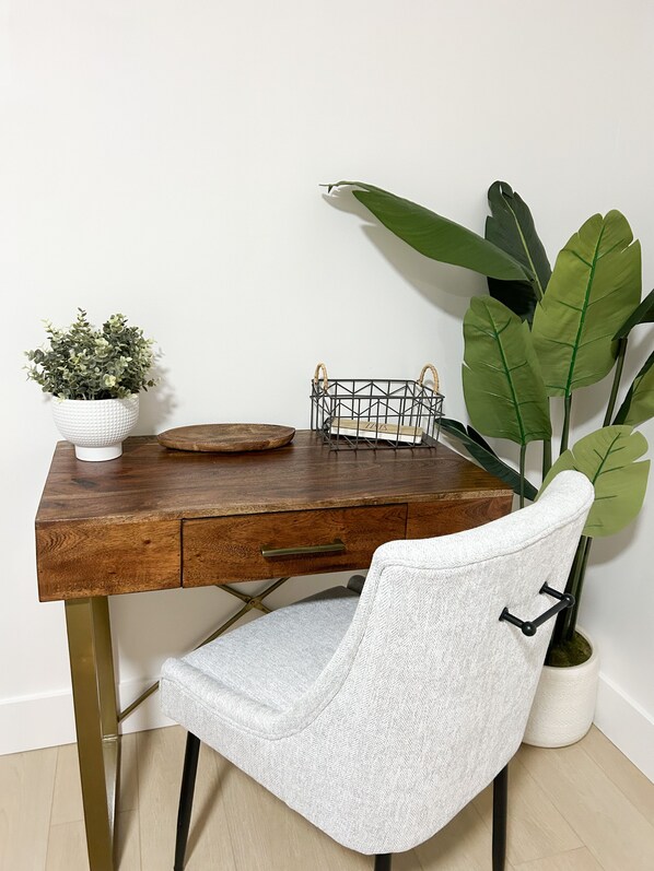 A wooden desk with a white chair, a potted plant, and a wire basket. - Fort Lauderdale - Heated Pool • Close to Beaches (Fort Lauderdale)