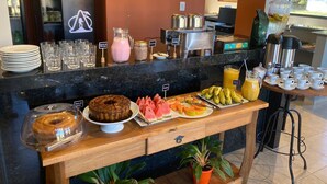 A breakfast buffet with various food items and beverages. - Pousada Apear (Andradas)