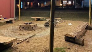 An outdoor area with string lights, wooden furniture, and a building in the background. - Pousada Apear (Andradas)