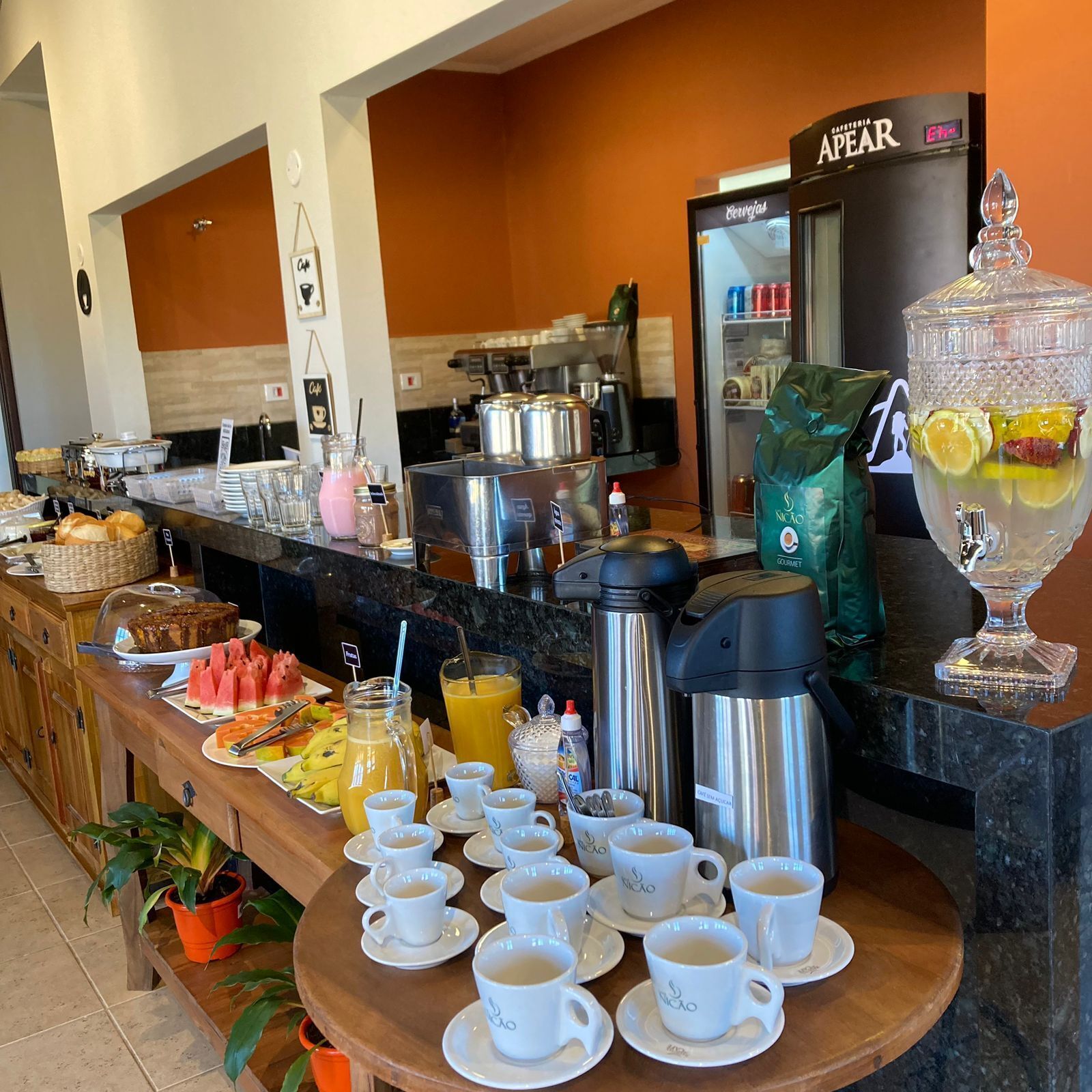 A buffet area with a variety of food items, coffee and tea service, and a coffee machine.