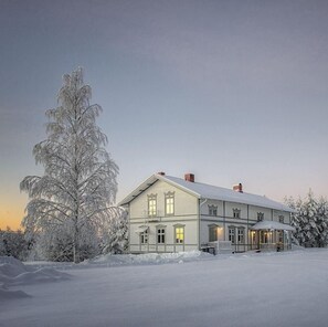 A large, two-story house with a symmetrical facade, a central entrance, and a covered porch. - LantLiv I Österjörn AB (Jörn)