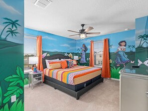 A bedroom with a bed, a nightstand, a dresser, and a ceiling fan.