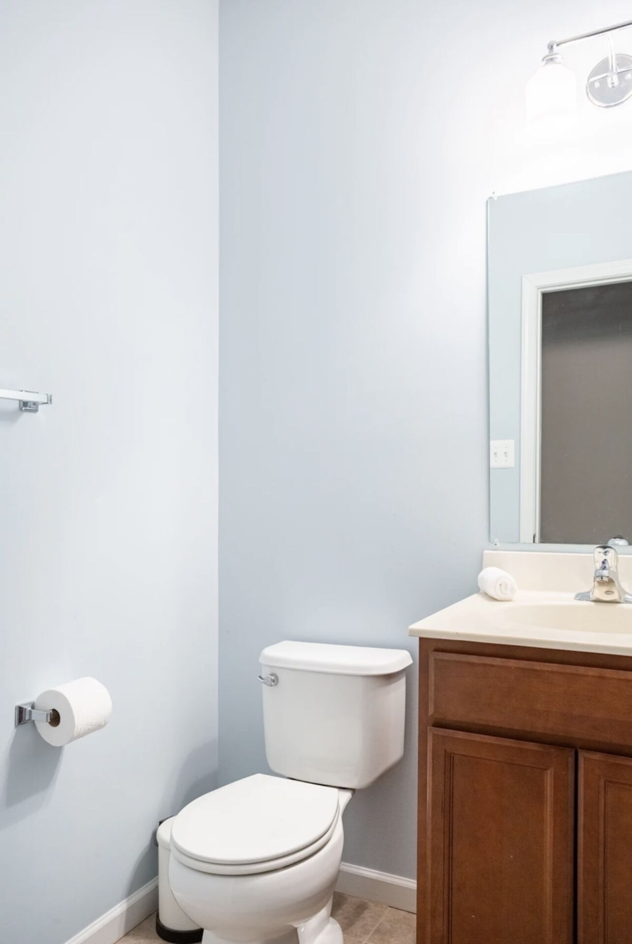 Un baño con inodoro, lavamanos y espejo.