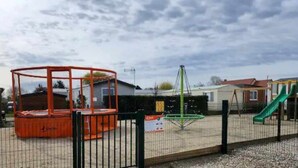 A playground with a swing set, a slide, and a climbing structure. - Modern Mobilome (Petit-Caux)