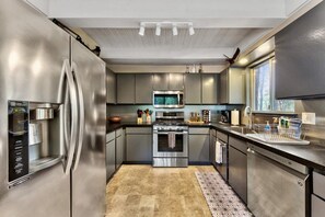A modern kitchen with stainless steel appliances, a built-in oven, and a microwave.