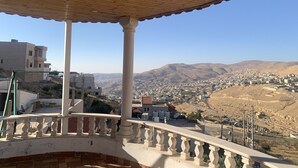A balcony with a view of a city and mountains. - Paradise Tree  (Wadi Musa)
