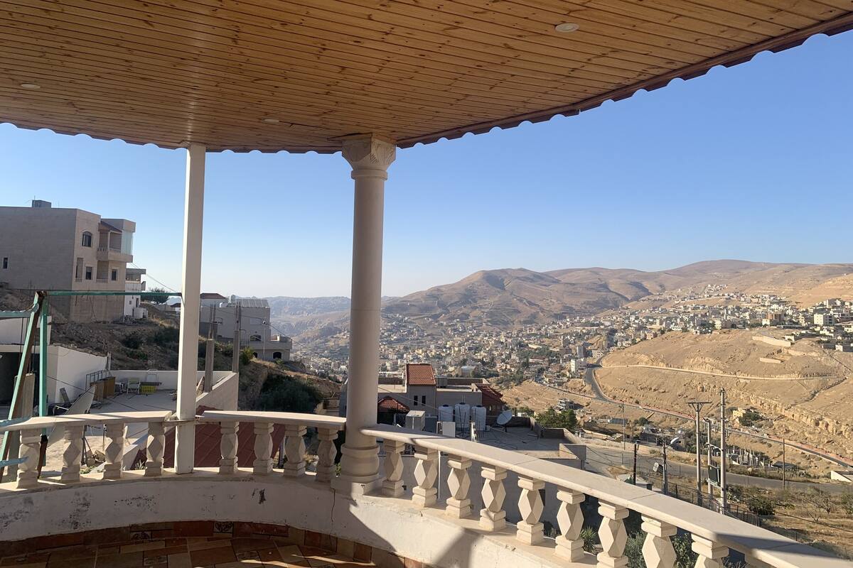 A balcony with a view of a city and mountains.