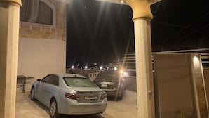 A parking area with two cars parked under a covered structure with lights. - Paradise Tree  (Wadi Musa)