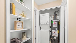 A compact bathroom with a white toilet, a towel rack, and a heater.