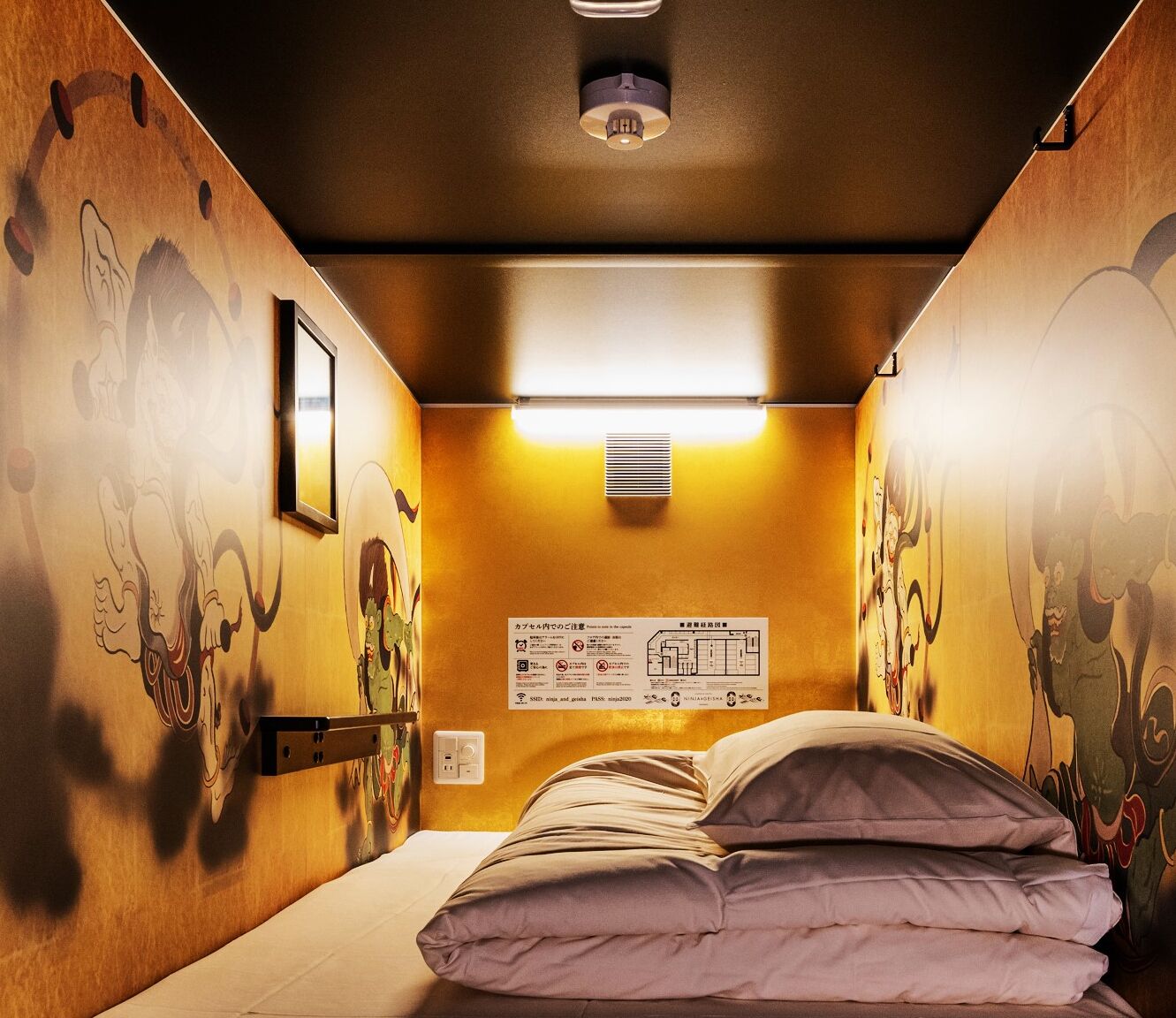 A hotel room with a bed, a wall map, and a ceiling light.