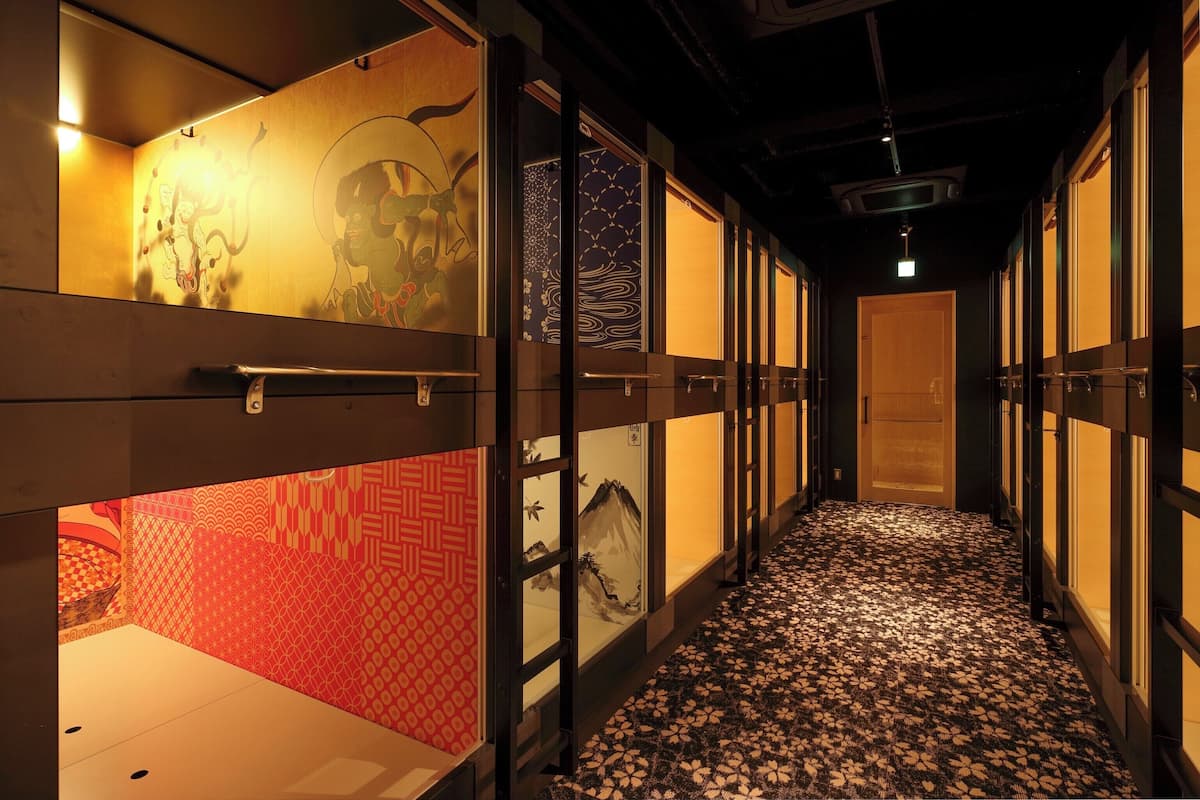 A corridor with traditional decor, including patterned walls and a carpeted floor.
