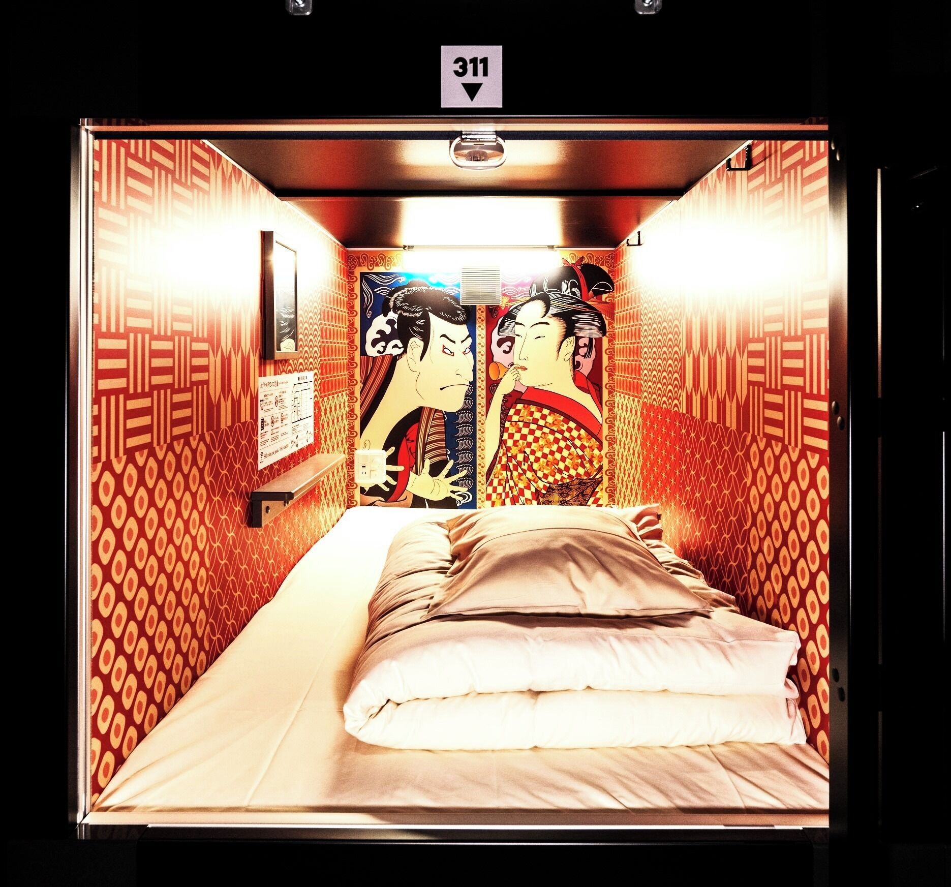 A room with a bed, a wall clock, and a door with a number sign.