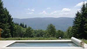 A rectangular pool with a clear view of mountains in the background. - Maison de Campagne (Saint-Amans-Valtoret)