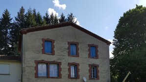 A two-story building with a flat roof, multiple windows with shutters, and a satellite dish. - Maison de Campagne (Saint-Amans-Valtoret)