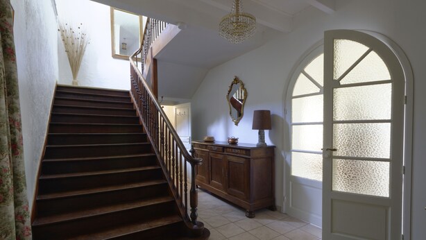 A staircase with wooden steps and a railing, leading to a room with a cabinet and a lamp. - Maison de Campagne (Saint-Amans-Valtoret)