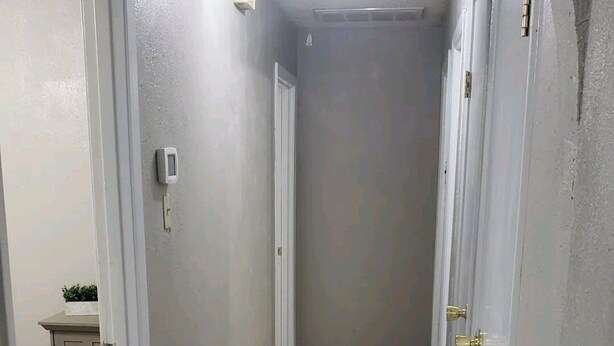 A narrow hallway with wooden flooring, white walls, and a ceiling light. - 5 minutes from Tech/UMC // book a quaint 3 bedroom home w/wifi and laundry (Lubbock)