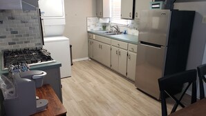 A compact kitchen with a gas stove, a refrigerator, and a sink. - 5 minutes from Tech/UMC // book a quaint 3 bedroom home w/wifi and laundry (Lubbock)